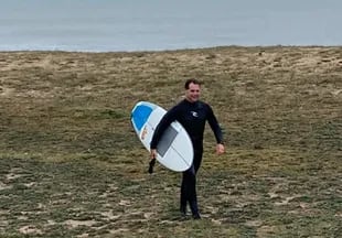 El presidente surfer. Lacalle Pou sale del agua después de una sesión de mediados de junio, en Maldonado (El País).