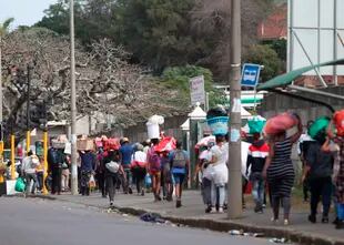 Una caravana de gente con productos saqueados de un centro comercial en Durban