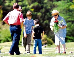 Nené Dalmasso, madre de Nora, al dejar flores en la tumba de su hija años atrás. 