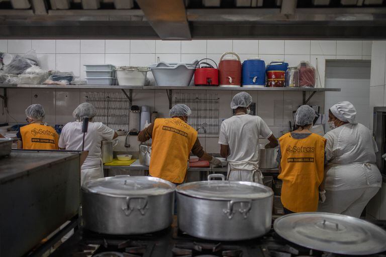 Voluntarios de una organización de caridad católica cocinan para un comedor público en San Pablo