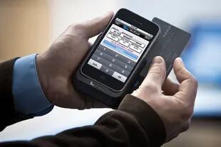 Un lector de Verifone adosado a un teléfono iPhone permite  realizar transacciones con tarjeta de crédito, y reemplazan de forma paulatina al uso de billetes