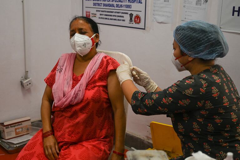 Un trabajador médico inocula a una mujer con una dosis de la vacuna Covishield en el hospital Rajiv Gandhi Super Specialty en Nueva Delhi, la India, el 29 de abril de 2021