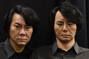 El experto en robótica Hiroshi Ishiguro, profesor emérito de la Universidad de Osaka, posa junto a un autómata que lleva su rostro, como parte de los robots sociales antropomórficos que desarrolla desde hace décadas