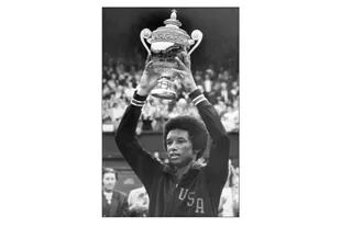Ashe, encumbrando el trofeo de Wimbledon, luego de vencer a Jimmy Connors en la final de 1975