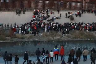 A crowd of migrants gathers on the banks of the Rio Grande (Rio Grande) on Tuesday, December 20, 2022, in front of the border wall in El Paso, Texas, as seen from Ciudad Juárez, Mexico.  (AP Photo/Christian Chavez)