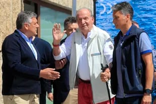 Mantan Raja Juan Carlos dari Spanyol, tengah, melambai sebelum resepsi di klub kapal pesiar menjelang acara berperahu pesiar di Sanxenxo, barat laut Spanyol, Jumat, 20 Mei 2022.