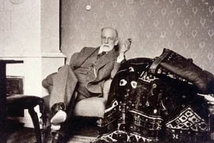 Sigmund Freud, junto a su célebre diván, en una fotografía de 1932