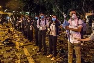 Los manifestantes forman una cadena humana para pasar artículos a la primera línea durante los enfrentamientos con la policía mientras intentan marchar hacia la Universidad Politécnica de Hong Kong el 18 de noviembre de 2019