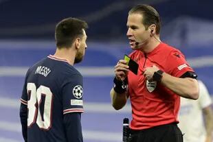 El árbitro neerlandés Danny Makkelie discute con Lionel Messi durante el encuentro entre PSG y Real Madrid