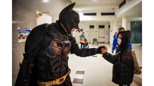 Batman saluda a un chico mientras sale del hospital