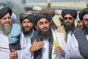 Mujahid (centro) habló con la prensa en el aeropuerto de Kabul
