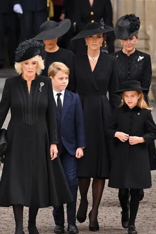 Camilla, la reina consorte junto con Kate, la princesa de Gales, el príncipe George y la princesa Charlotte abandonan la Abadía de Westminster después del funeral.  Detrás, la condesa de Wessex y la duquesa de Sussex, sin ocultar su dolor.