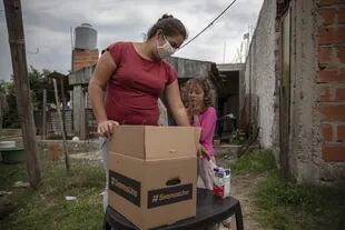 Una familia recibe una caja de asistencia de la iniciativa SeamosUno, en José C. Paz
