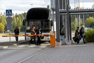 Los pasajeros se bajan de un autobús mientras esperan para ingresar a Finlandia desde Rusia en el puesto de control fronterizo de Nuijamaa en Lappeenranta.