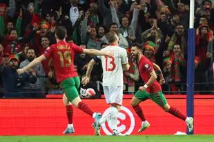 Portugal's Bruno Fernandes, right, celebrates after scoring the opening goal during the World Cup 2022 playoff soccer match between Portugal and North Macedonia, at the Dragao stadium in Porto, Portugal, Tuesday, March 29, 2022. (AP Photo/Luis Vieira)