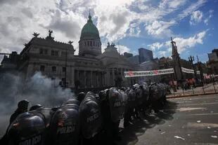 La policía  toma posición después de que estallaron los enfrentamientos durante una protesta contra el acuerdo entre el gobierno argentino y el Fondo Monetario Internacional frente al Congreso en Buenos Aires.