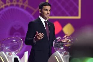 El exfutbolista australiano Tim Cahill habla en el escenario durante el sorteo de la Copa Mundial 2022 en Qatar.