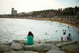 Una mujer está sentada junto a la playa en Barcelona el 28 de julio de 2022