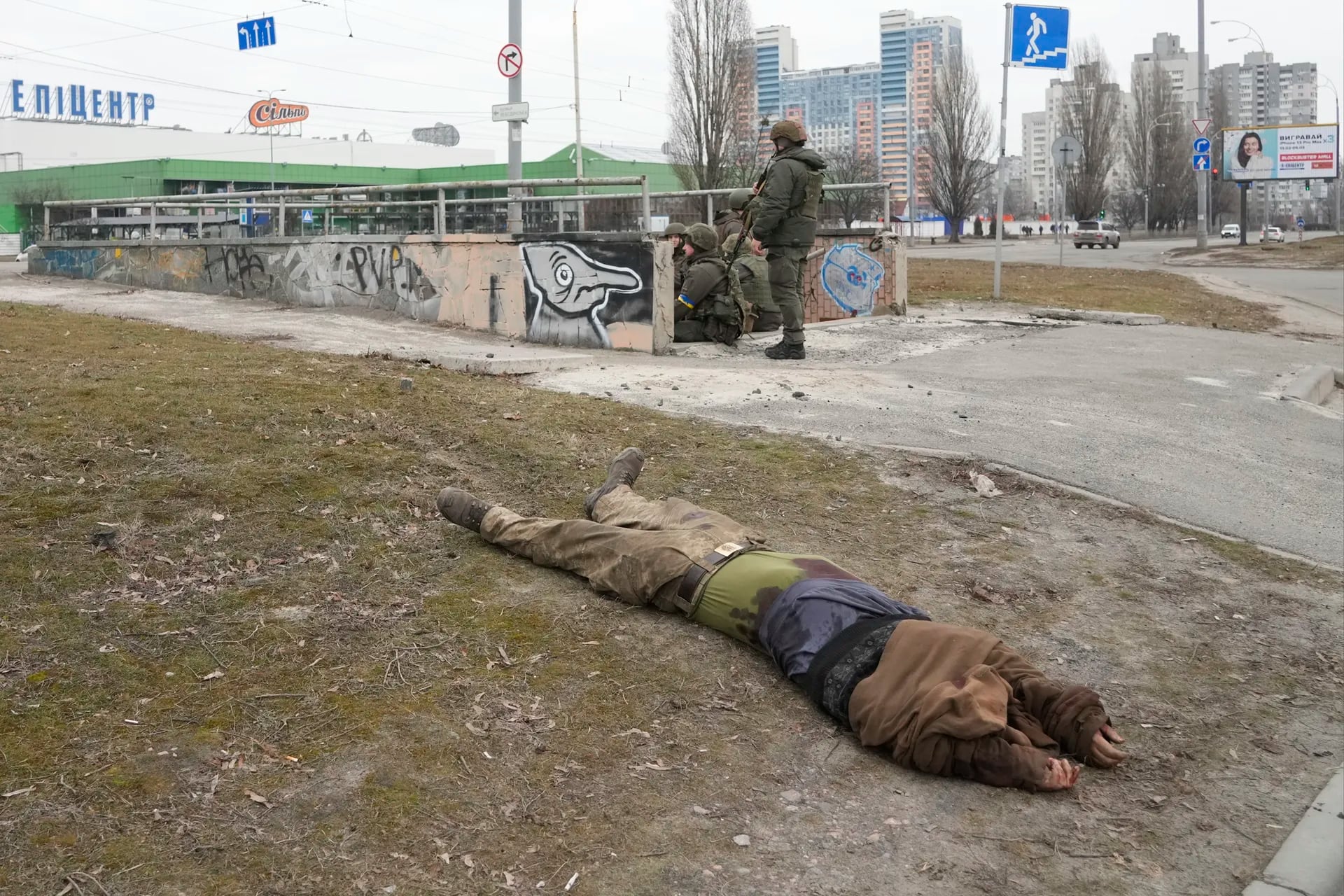 Soldados del ejército ucraniano frente al cuerpo sin vida de un soldado en Kiev