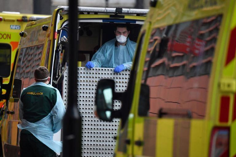 Paramédicos con EPP completo preparan una ambulancia frente al Royal London Hospital en el este de Londres