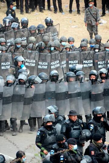 Fuerzas de seguridad, con sus escudos antidisturbios, bloquean a migrantes que llegaron en caravana a Vado Hondo, Guatemala, desde Honduras rumbo a Estados Unidos