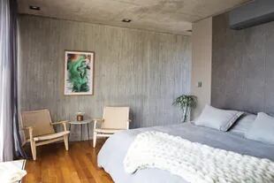  En la suite, silloncitos y mesa baja (Landmark) y acrílico sobre tela "Caída Libre", de la artista María Alejandra Fernández. Para disimular los aires acondicionado, en toda la casa se pintaron con esmalte sintético gris.