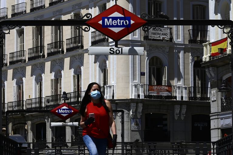 Una mujer camina con barbijo por la Puerta del Sol, una plaza de la ciudad española de Madrid, en medio de la pandemia de coronavirus