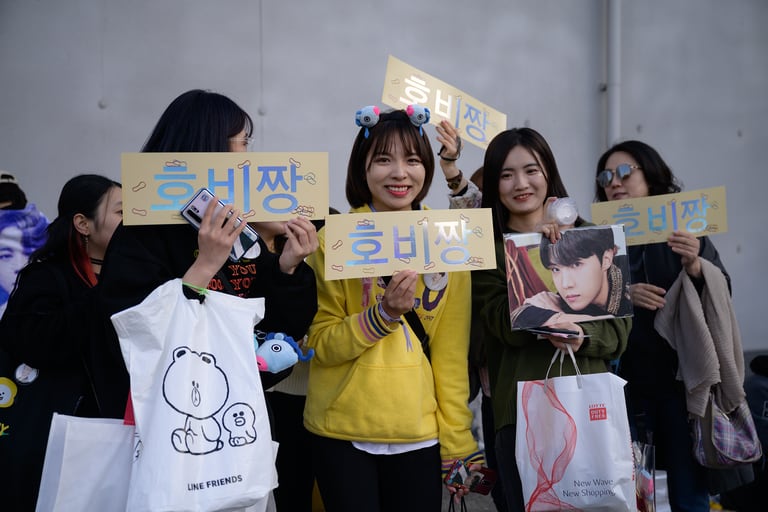 En esta foto de archivo tomada el 29 de octubre de 2019, los fanáticos del grupo BTS de K-pop de Corea del Sur posan para fotos fuera del lugar del concierto de la banda en el estadio olímpico de Seúl