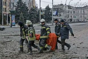 El personal del servicio de emergencia ucraniano lleva el cuerpo de una víctima después del bombardeo que golpeó el edificio del Ayuntamiento en Kharkiv, Ucrania, el martes 1 de marzo de 2022