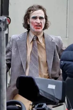 El look de Joaquin Phoenix: fue visto en el set con un traje gris claro, una camisa de vestir beige y una corbata de rayas grises y lilas