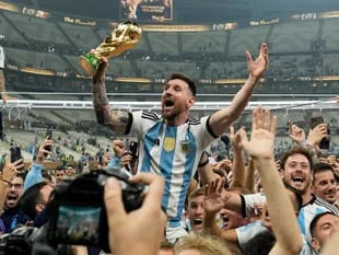 El argentino Lionel Messi celebra con el trofeo ante los hinchas tras ganar el Mundial en la final entre Argentina y Francia en el estadio Lusail de Lusail, Qatar, el 18 de diciembre de 2022. (AP Foto/Martin Meissner)