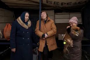 Tres personas que huyeron de la aldea de Ruska Lozova esperan en un puesto de control en Járkiv, Ucrania, el 29 de abril de 2022. (AP Foto/Felipe Dana)