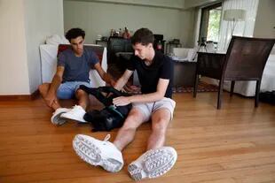 En la intimidad de los Cerúndolo: Francisco y Juan Manuel, en su casa, jugando con Milos, el perro de la familia.