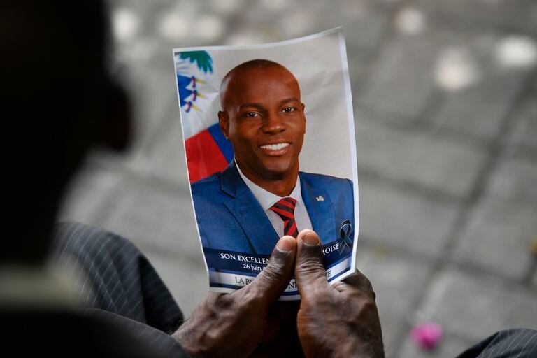 Una persona sostiene una fotografía de difunto presidente Jovenel Moïse durante una ceremonia fúnebre en el Museo y Cementerio Nacional, el martes 20 de julio de 2021, en Puerto Príncipe, Haití. (AP Foto/Matias Delacroix, Archivo)