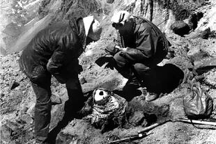 El laboratorista Julio Ferrari prepara el fardo funerario para su descenso. Lo acompaña el andinista Juan Carlos Pierobón