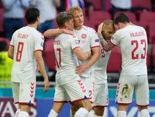 Abrazos entre los futbolistas de Dinamarca, una selección que por momentos pasó por arriba a Gales en el primer partido de los octavos de final de la Euro 2020.