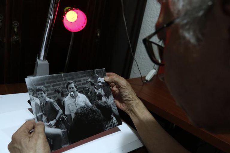 Édgar Jiménez, el Chino, sostiene fotos que le tomó al capo en las calles de Medellín