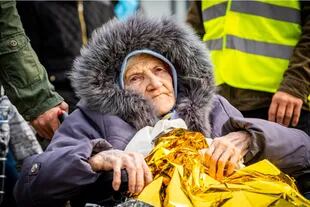 Señora descansa en su paso por el corredor humanitario de Medyka, Polonia, luego de realizar horas de fila para cruzar la frontera.