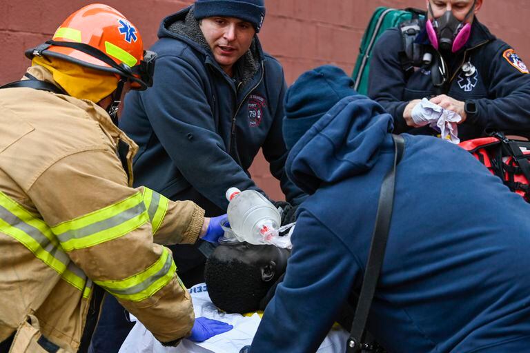 Personal de emergencia trabaja en una víctima de un incendio en la calle East 181 Street, el domingo 9 de enero de 2022, en el distrito del Bronx de Nueva York. (Foto AP/Lloyd Mitchell)