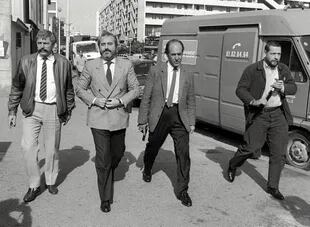 El juez Falcone (segundo desde la izquierda), rodeado de guardias armados, en una imagen de 1986, el año previo a la condena de la Cosa Nostra