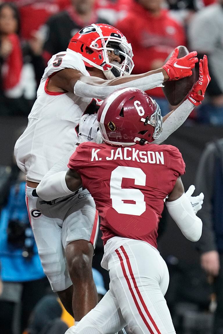 El jugador de Georgia Adonai Mitchel atrapa un pase de touchdown por encima de Khyree Jackson, de Alabama,  en la segunda mitad de su partido por el Campeonato Universitario de Fútbol Americano, el lunes 10 de enero de 2022 en Indianápolis. (AP Foto/Darron Cummings)