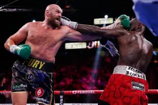 Tyson Fury, de Inglaterra, golpea a Deontay Wilder en la pelea de campeonato mundial de pesos pesados del 9 de octubre de 2021, en Las Vegas.