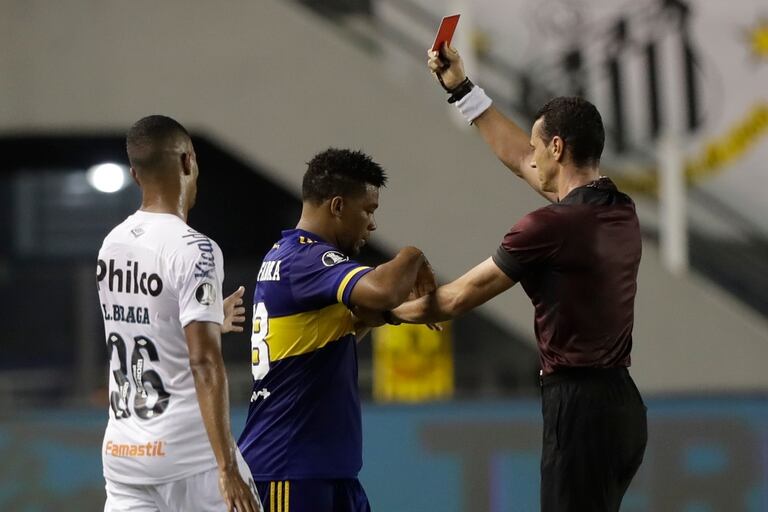El árbitro Wilmar Roldán, a la derecha, muestra la tarjeta roja a Frank Fabra de Boca Juniors de Argentina, en el centro, durante el partido de vuelta de la semifinal de la Copa Libertadores contra el Santos de Brasil en Santos, Brasil, el miércoles 13 de enero de 2021