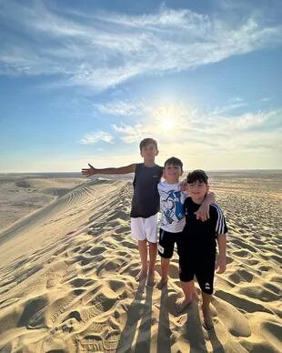 Thiago, Ciro y Mateo posan para la cámara en un desierto de Qatar