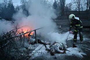 Un bombero apaga los cuerpos de los transeúntes muertos tras un ataque aéreo que golpeó la principal torre de televisión de Kiev en Kiev el 1 de marzo de 2022.