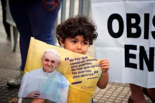 Un niños sostiene un cartel mientras espera ver al Papa que recorre las calles de Santiago de Chile