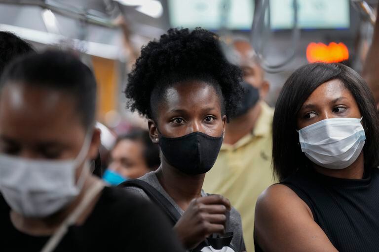 Personas usan mascarillas mientras caminan en una estación de metro en Sao Paulo, Brasil, el miércoles 1 de diciembre de 2021. (AP Foto/Andre Penner)