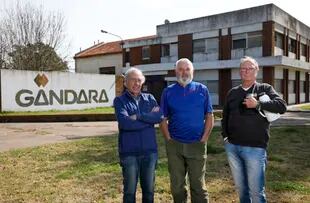 Luis Hoyos, Oscar Sueldía y Luis Pommerenck se encuentran en la puerta de la planta de Gándara, décadas después del cierre de la fábrica que fue un ícono de la industria láctea