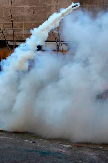 Policía antidisturbios disparando gases a los manifestantes durante la conmemoración del primer aniversario de la protesta en Chile