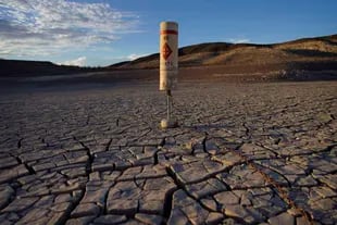 A buoy stands still on June 8, 2022, at the dry bottom of a portion of Lake Mead, in the Lake Mead National Recreation Area near Boulder City, Nevada.  (AP Photo/John Locher)